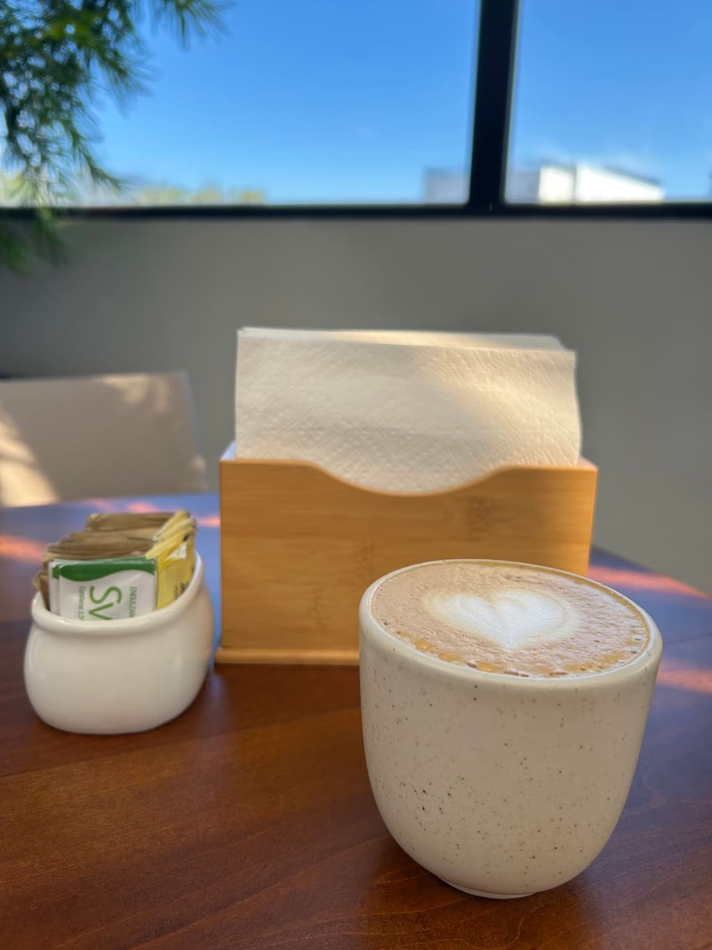 Capuchino con arte latte de corazón sobre mesa de madera