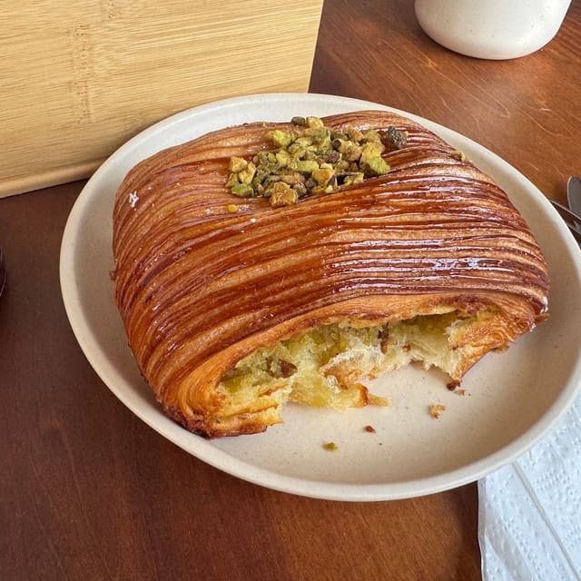 Croissant glaseado cubierto de pistache troceado