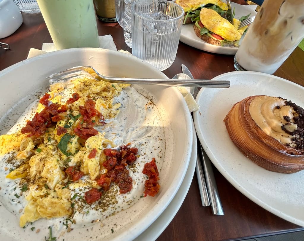 Desayuno en la terraza: huevos con pan pita, ensalada y croissant